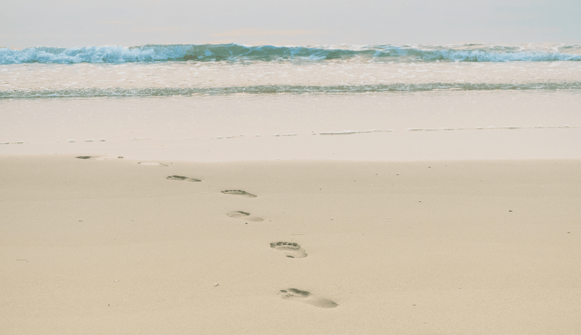 Photo de trace de pied sur une plage de sable fin